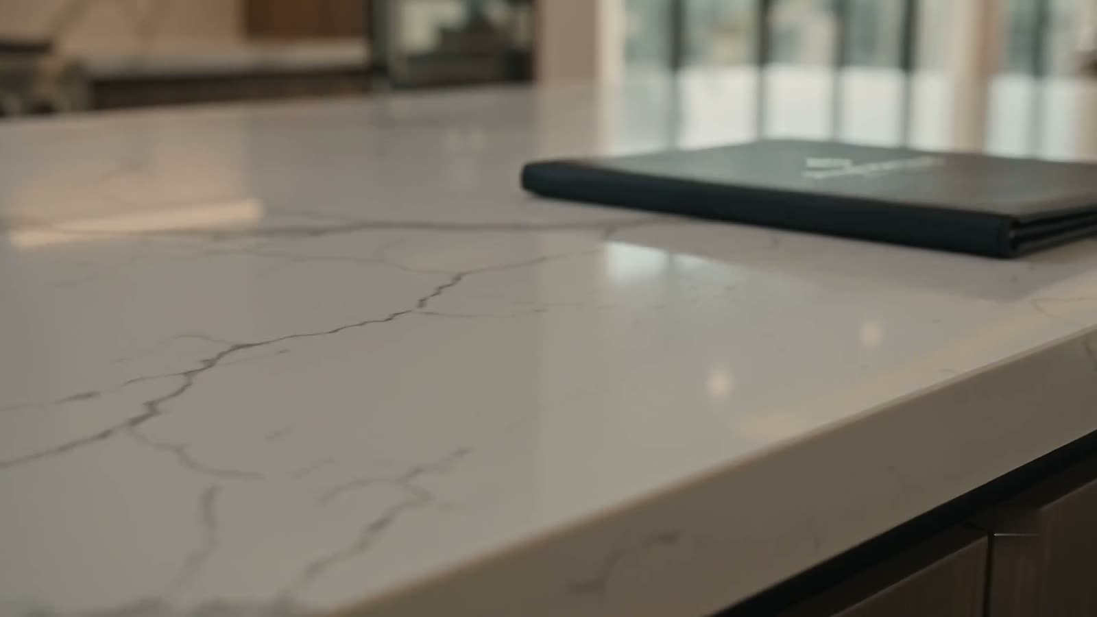 A Permit Matching project portfolio resting on a marble kitchen island in a finished custom home